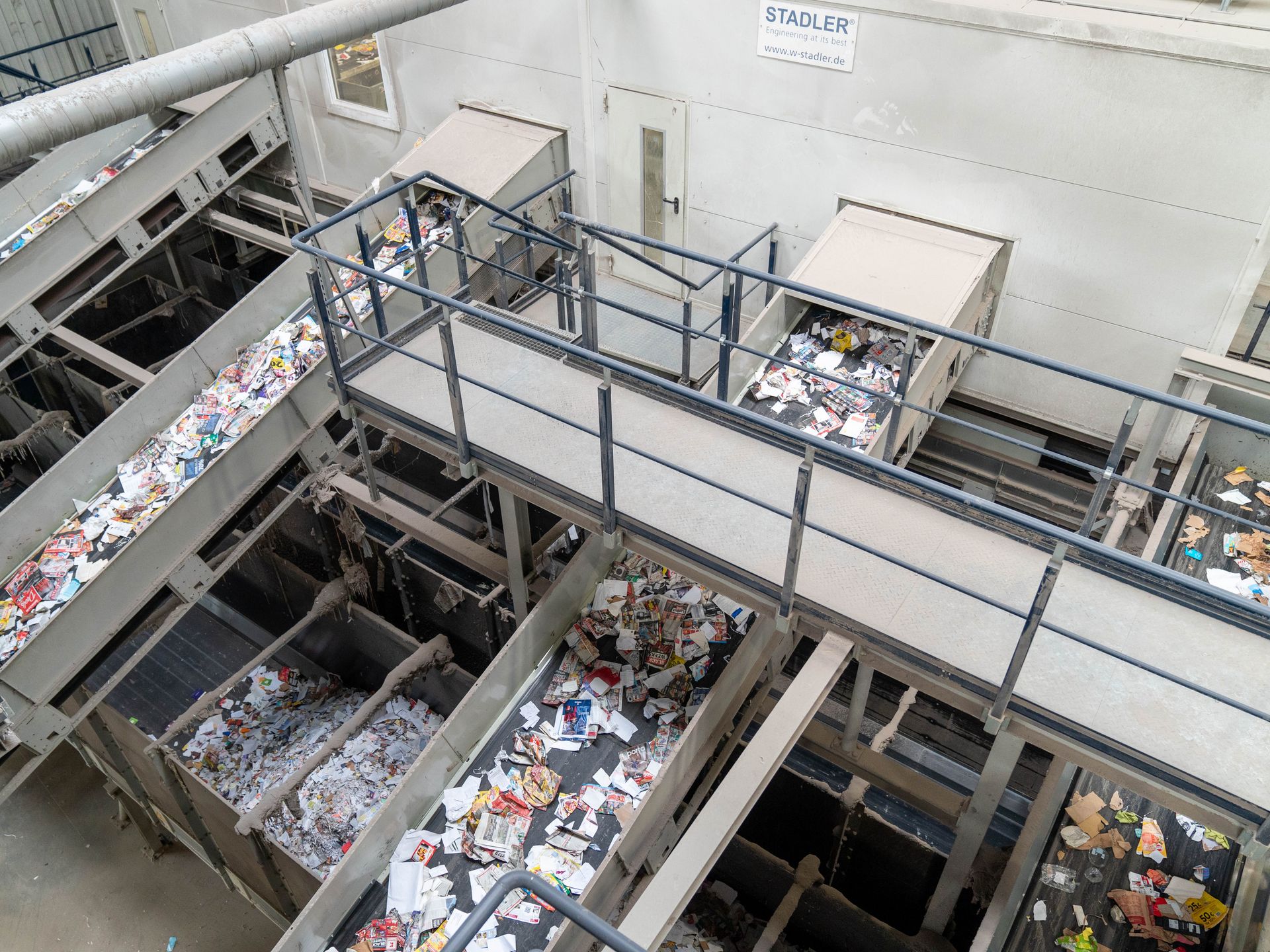 Förderbänder in der Papieraufbereitungsanlage Komplexe Anlage mit vielen Fördernbändern, auf denen Papier und Pappe transportiert wird
