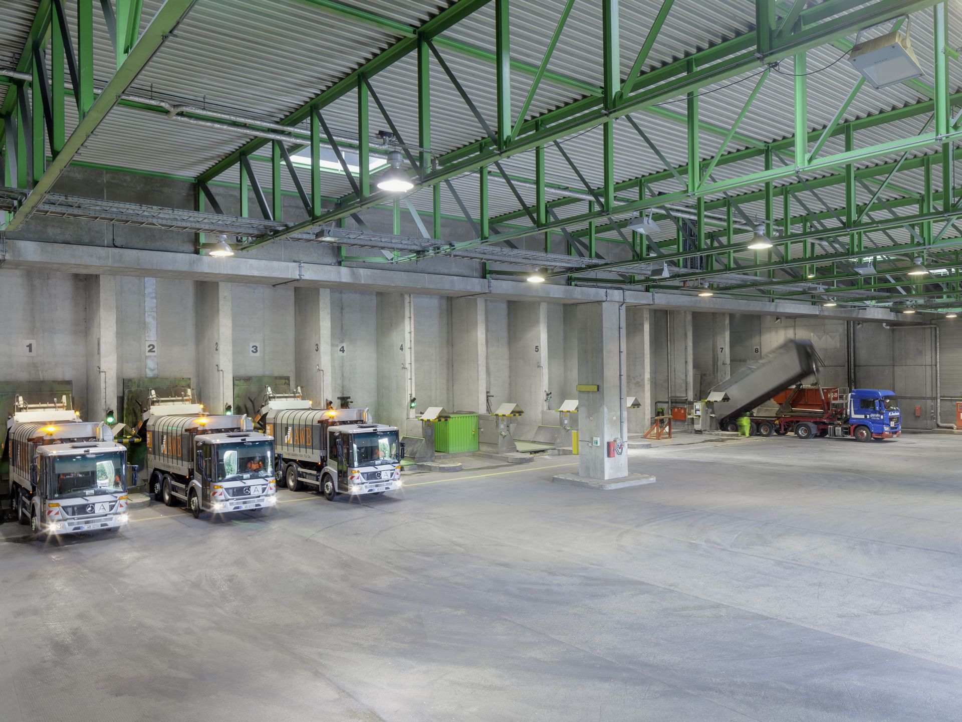 Drei Müllfahrzeuge der AWB Köln entladen in der Anlieferhalle Hausmüll Drei Müllfahrzeuge der AWB Köln stehen mit dem Heck in der Anlieferhalle der Restmüllverbrennungsanlage, und kippen den Hausmüll in den Tagesmüllbunker