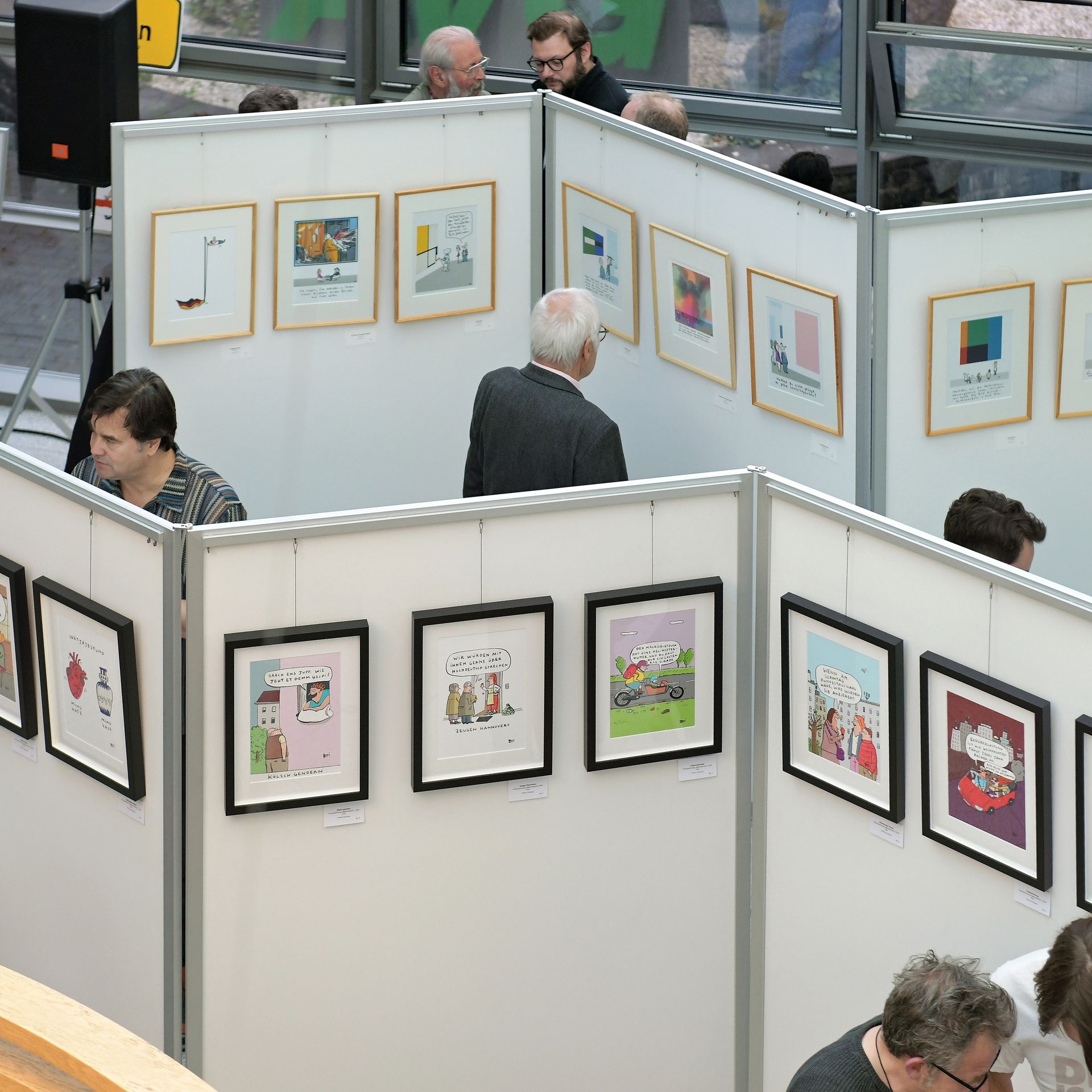 Stellwände mit vielen bunten Cartoons, Menschen, die sich Bilder ansehen 